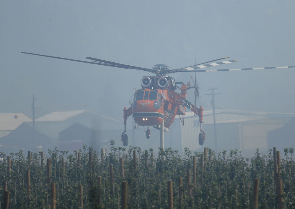 A tanker helicopter used for fighting wildfires takes off Tuesday just outside of Chelan, Wash. The Pacific Northwest is getting top priority for pinched firefighting resources.
