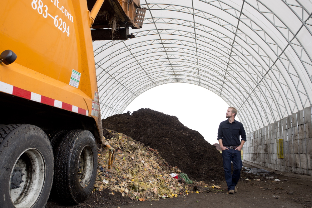 Brett Richardson of We Compost It! watches as his truck, operated by Emily Seluta (not pictured), dumps food waste into a large structure at CPRC Group in Auburn. The waste will be turned into compost.