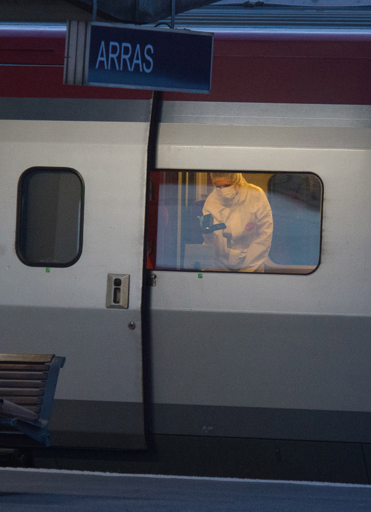 A police officer videos the crime scene in a train at the station in Arras, France, on Friday after a gunman opened fire as the train was traveling from Amsterdam to Paris.