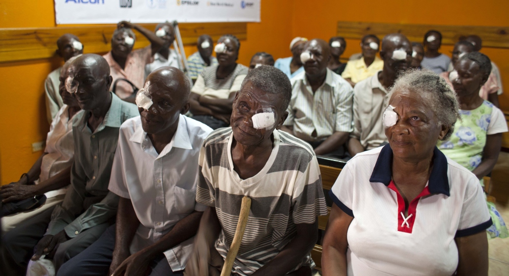 Mathieux Saint Fleur, 75, second from right, waits with other patients who had cataracts removed to have their bandages taken off one day after surgery in Cap-Haitien, Haiti.