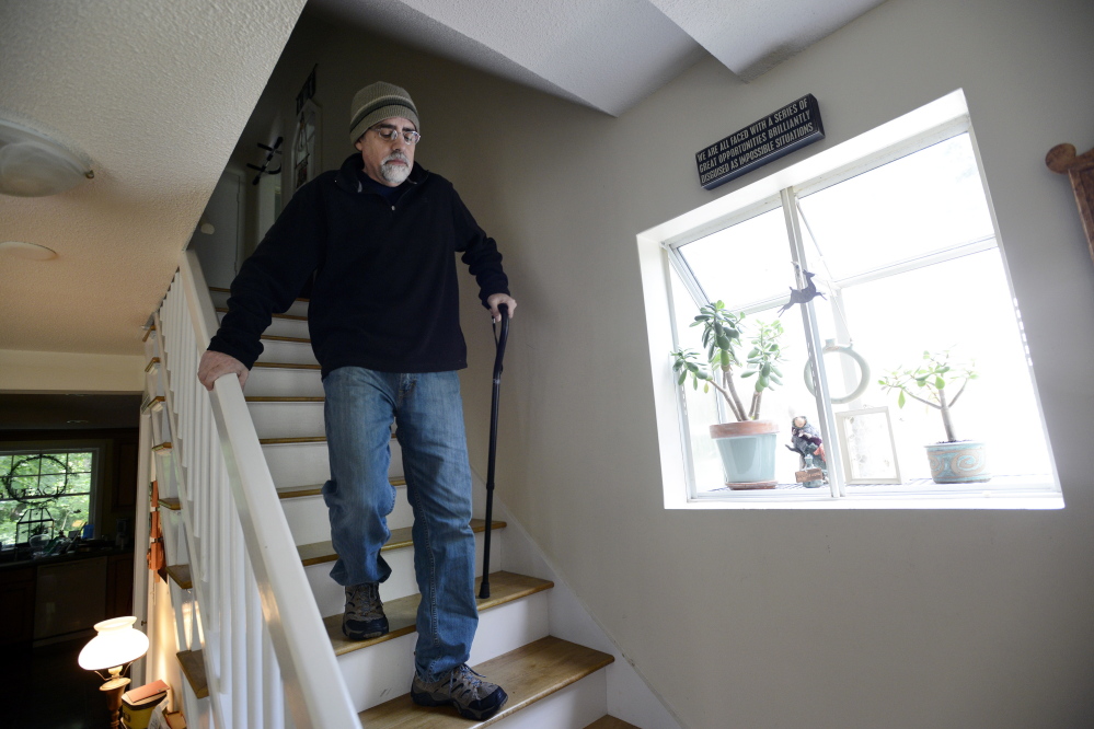 Bob Sprankle struggles to navigate the stairs at his home in Portsmouth, N.H. The 52-year-old former Wells Elementary School teacher used to run 4 miles a day, but now is largely confined to his home. His applications for disability were denied, but he lives with too much pain to work, so he lost his $71,000 salary as well.