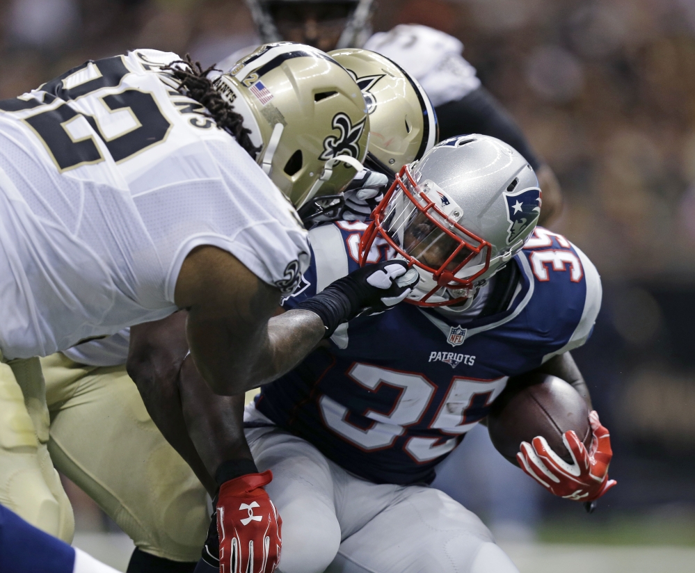 Jonas Gray of the New England Patriots has his facemask yanked by John Jenkins of the New Orleans Saints during the first half of their preseason game Saturday night.