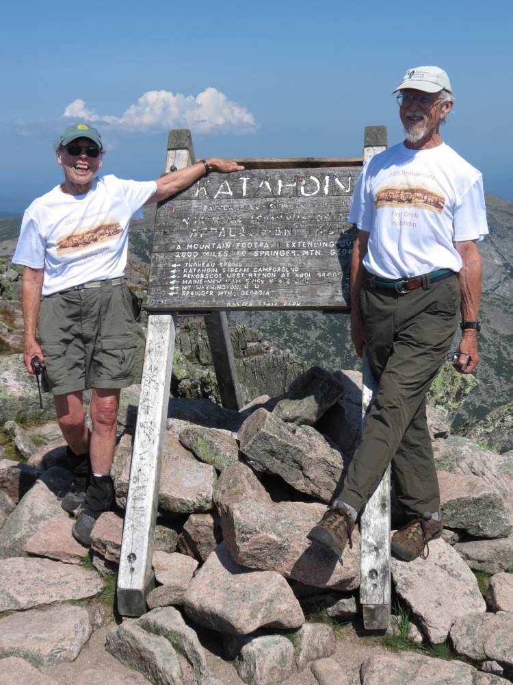 Lurana Brower McCarron and John Brower stand in front of the sign at the top of Katahdin.