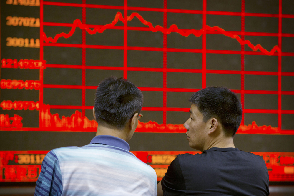 Chinese investors monitor stock prices at a brokerage house in Beijing on Tuesday, as China’s main stock market index fell for a fourth day, plunging 7.6 percent to an eight-month low.