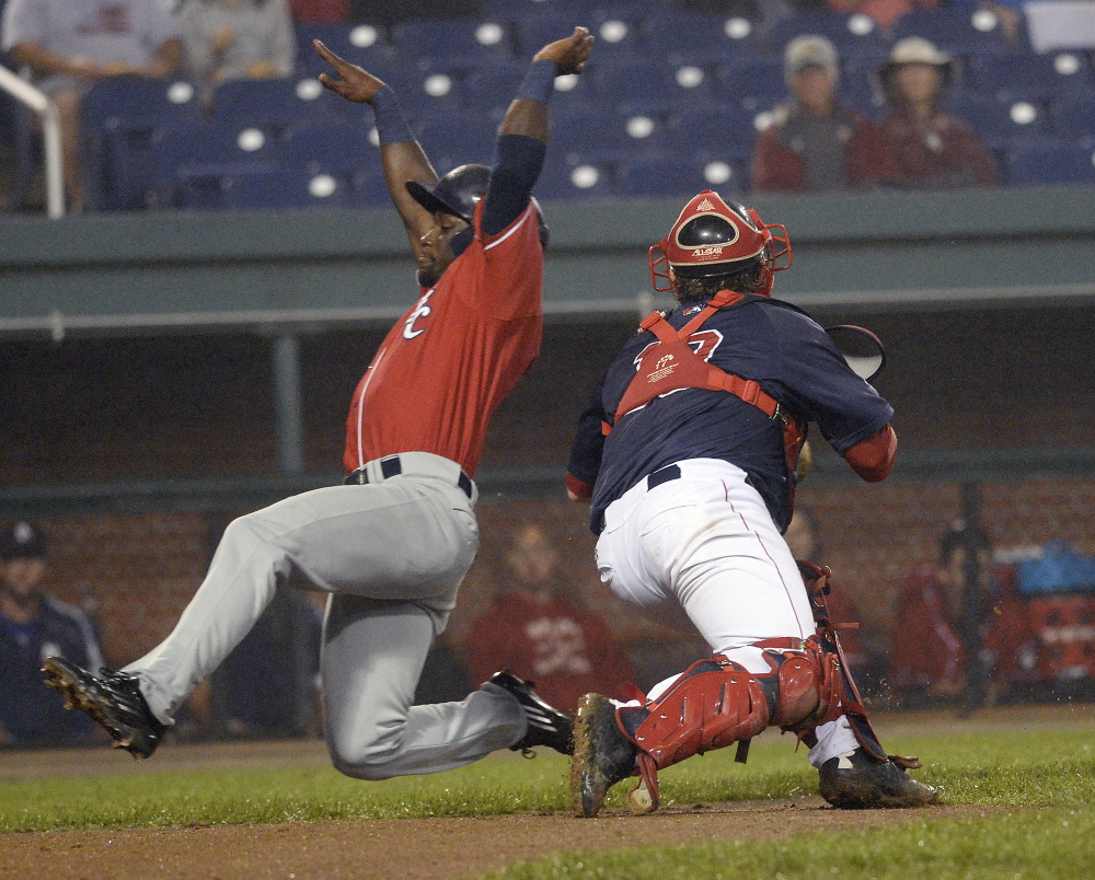 Roemon Fields of the Fisher Cats slides safely around Sea Dogs catcher Tim Roberson during New Hampshire’s 3-0 win over Portland on Tuesday at Hadlock Field.