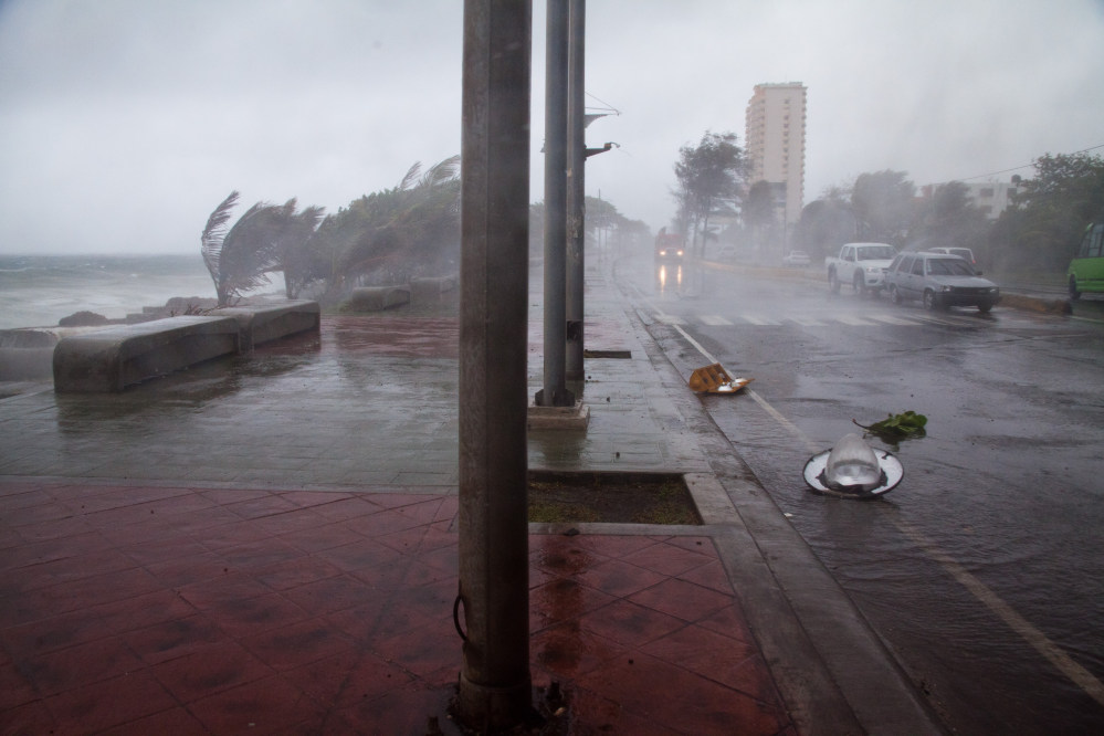 Broken traffic lights and street lamps lay on the ground as the strong winds of Tropical Storm Erika approach Santo Domingo, in the Dominican Republic, on Friday. Florida may be spared a similar impact.
