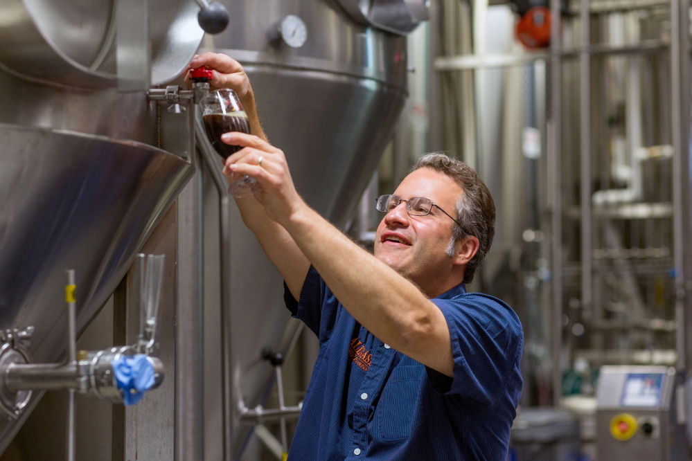 Founder and owner Rob Tod takes beer off a fermentor at Allagash Brewing Co. The Clean Water Rule will help protect the high quality of water from the Sebago Lake watershed, the source for Portland-based Allagash.