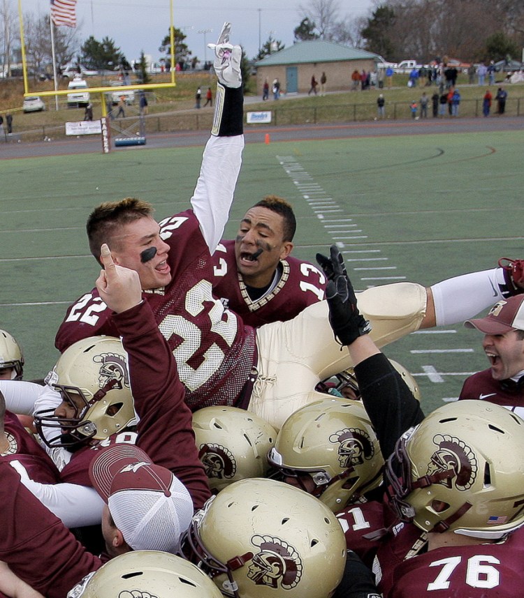 Corey Hart, 13, and C.J. Michaud, 22, were at the center of the celebration last year when Thornton Academy beat Windham in the Class A football state championship game. The Trojans are again a favorite.