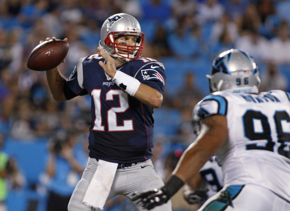 Tom Brady looks to pass under pressure from the Panthers’ Wes Horton during the first half Aug. 28. Brady finally got on track late in the first half, after throwing two interceptions.