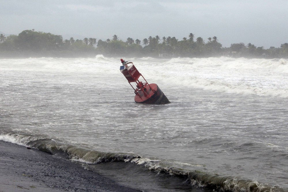 A large navigation buoy hit by strong winds and waves, floats near the coast, as Tropical Storm Erika moves away from the area in Guayama, Puerto Rico, Friday. The storm was expected to dump up to 8 inches of rain across the drought-stricken northern Caribbean as it carved a path toward the U.S. The Associated Press