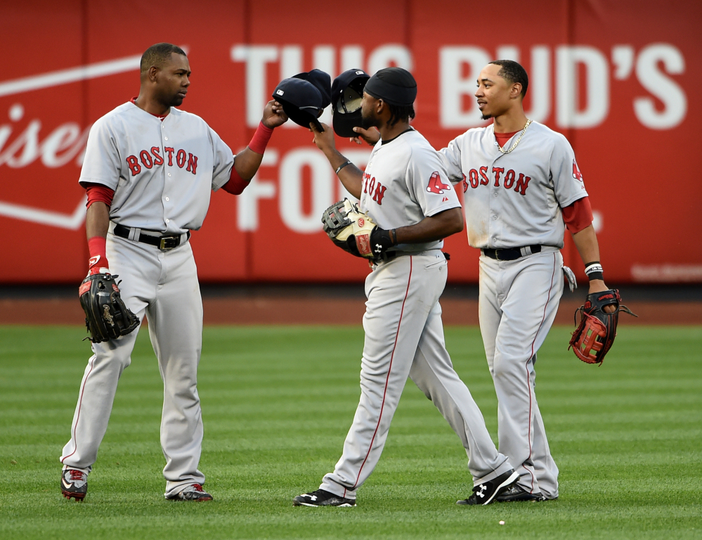 Boston Red Sox’s Alejandro De Aza, left, Jackie Bradley Jr., center, and Mookie Betts celebrate their 3-1 win over the New York Mets  at Citi Field on Saturday in New York.