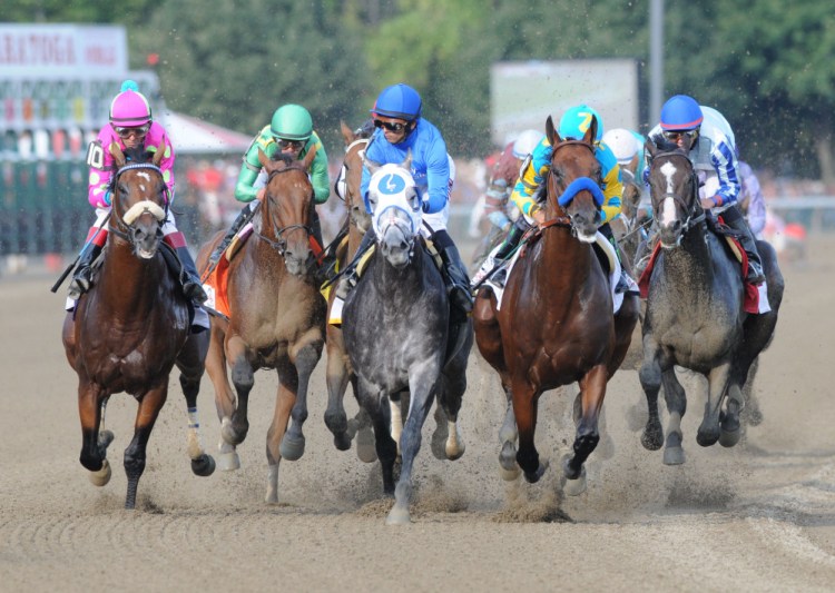 American Pharoah with Victor Espinoza, second from right, leads the field into the first turn during the Travers Stakes horse race at Saratoga Race Course in Saratoga Springs, N.Y., Saturday. The Associated Press/ Will Waldron/The Albany Times Union
