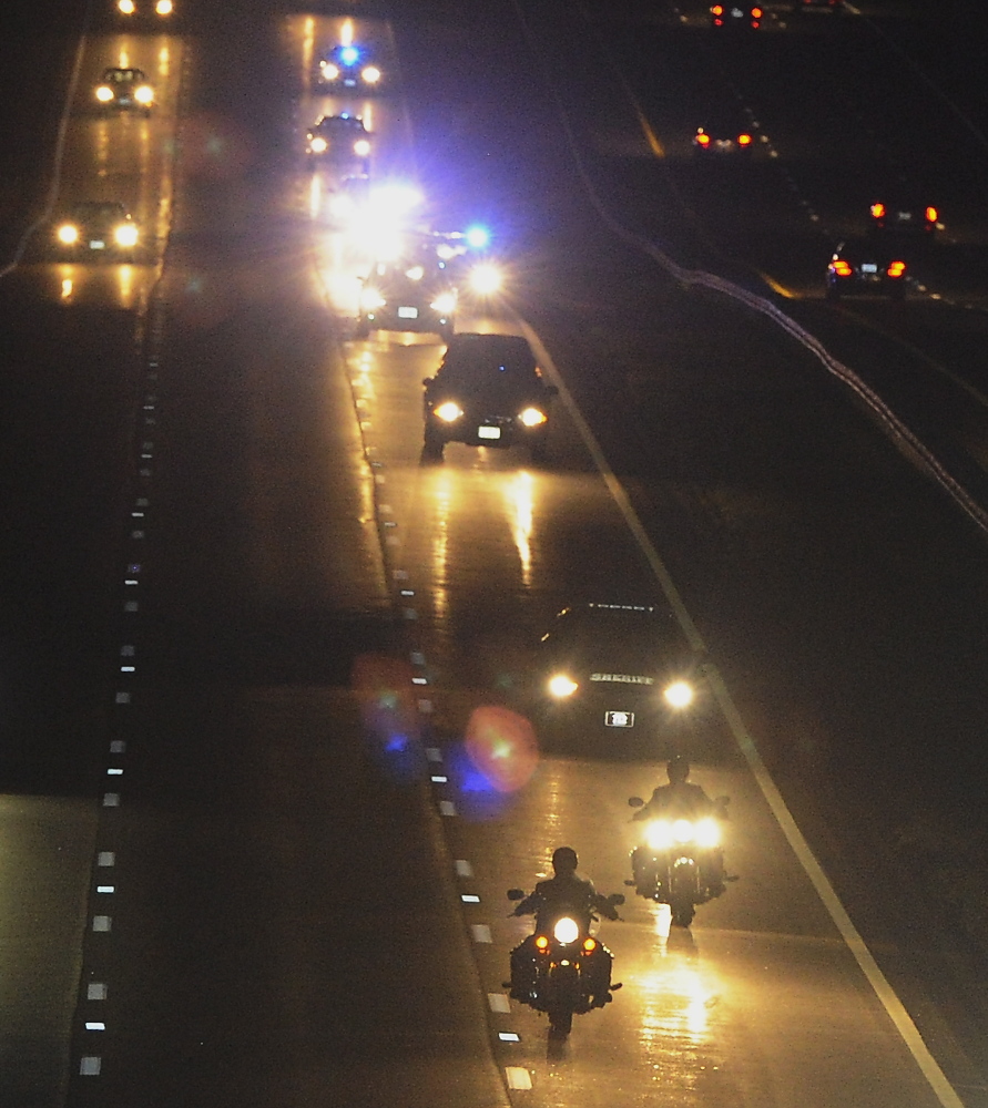 A procession escorts the remains of Corey Dodge by a Maine Turnpike overpass in Limerick on Saturday night.