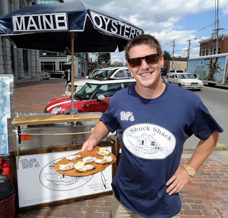 Brendan Parsons owner of  BP's Shuck Shack, presents a half-dozen oysters prepared in his food cart on Commercial Street. Gordon Chibroski/Staff Photographer