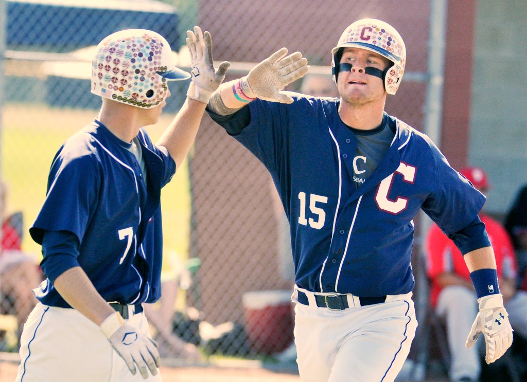 Sam Huston, right, exchanges a high-five with Trevor DeLaite after scoring a run for Coffee News in the American Legion baseball state championship game in South Portland on Sunday. Huston drove in six runs in Coffee News' 12-9 win over Morrill Post. John Ewing/Staff Photographer