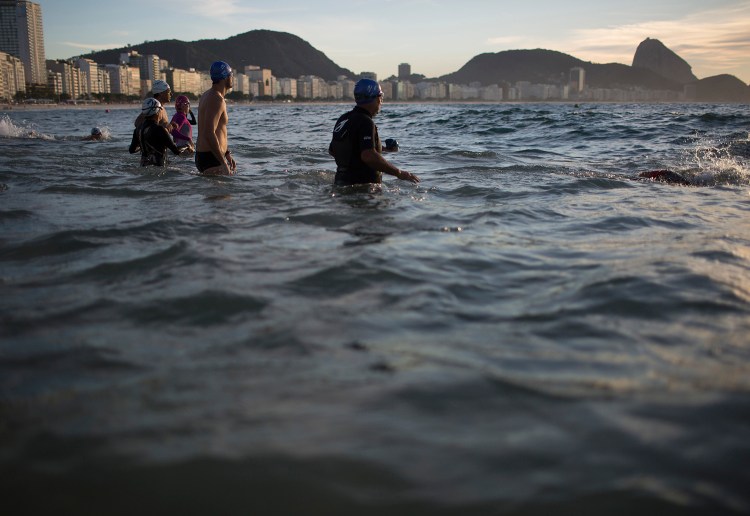 In this July 14, 2015 photo, beachgoers wade into the waters of Copacabana Beach in Rio de Janeiro, Brazil. An Associated Press analysis of water quality found not one water venue safe for swimming or boating in Rio's waters. Over 10,000 athletes from 205 countries are expected to compete in next year's Summer Olympics. Hundreds of them will be sailing in the waters near Marina da Gloria in Guanabara Bay; swimming off Copacabana Beach; and canoeing and rowing on the brackish waters of the Rodrigo de Freitas Lake. (AP Photo/Leo Correa)