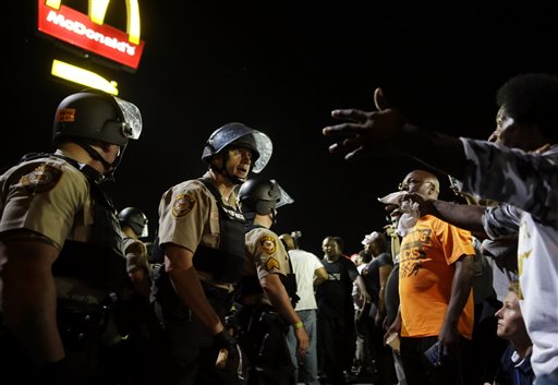 Officers and protesters face off along West Florissant Avenue, Monday in Ferguson, Mo. The Associated Press