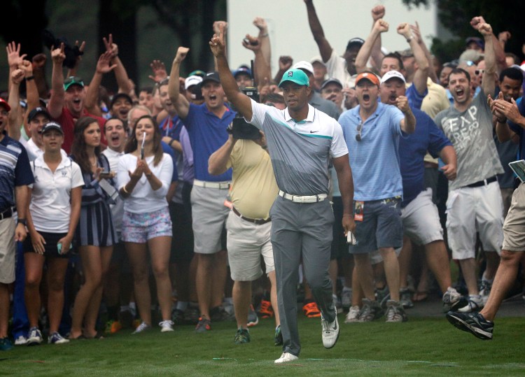 Tiger Woods reacts after holing out a chip shot on the 10th hole during the first round of the Wyndham Championship in Greensboro, N.C., on Thursday.
