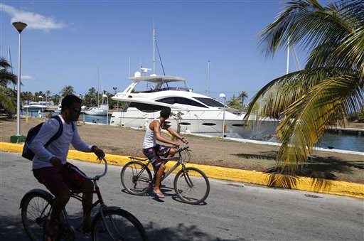 Cuban boys cycle past an American yacht moored at the Hemingway Marina in Havana, Cuba, Thursday. The elimination of all restrictions on nautical tourism appears to be eminent, says Jose Luis Perello, a tourism professor at the University of Havana. That won't just open the doors to Americans, but also to visitors from other countries and yacht clubs. The Associated Press