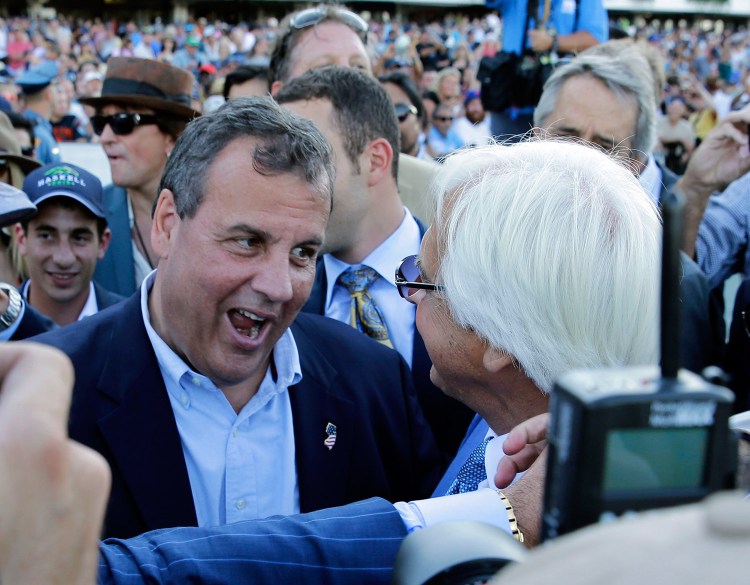 New Jersey Gov. Chris Christie, left, congratulates Triple Crown winner American Pharoah's trainer Bob Baffert after American Pharoah won the Haskell Invitational horse race at Monmouth Park in Oceanport, N.J., on Sunday. Christie on Sunday called a national teachers union "the single most destructive force in public education."
