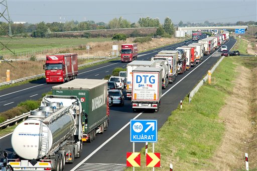 Vehicles  wait  on the M1 motorway near the border between Hungary and Austria Monday. Every vehicle capable of smuggling people is checked  at the border after 71 migrants were found dead in a truck Thursday.  The Associated Press