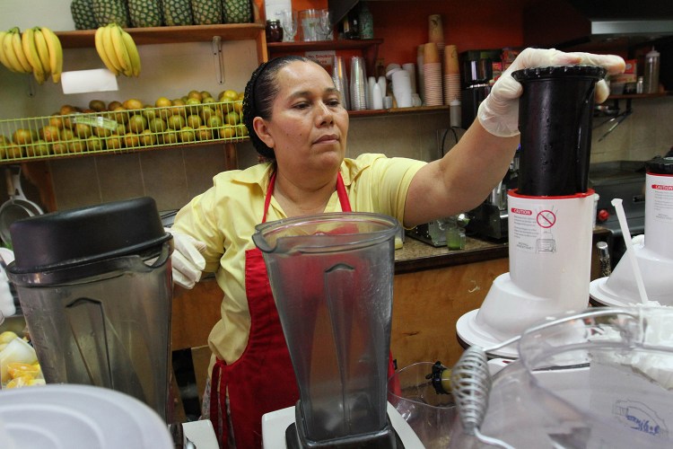 Celina Alvarez, 51, works at Jugueria de regreso al Eden, her shop in the Queens borough of New York. As a campaign to raise the minimum wage as high as $15 has rolled to victory in such places as Seattle, Los Angeles and New York, it has bumped up against a harsh reality: Plenty of scofflaw businesses don’t pay the legal minimum now and probably won’t pay the new, higher wages either. The Associated Press