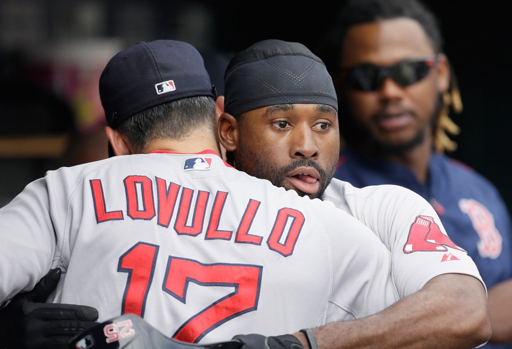 Boston Red Sox's Jackie Bradley Jr. hugs bench coach Torey Lovullo after scoring from third on a single by teammate Brock Holt during the eighth inning against Detroit. Bradley previously arrived at third on a three-run triple to right field. The Associated Press