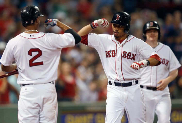 Red Sox center fielder Mookie Betts, center, celebrates his solo home run with teammate Xander Bogaerts in the seventh inning against the Kansas City Royals in Boston on Saturday. The Associated Press