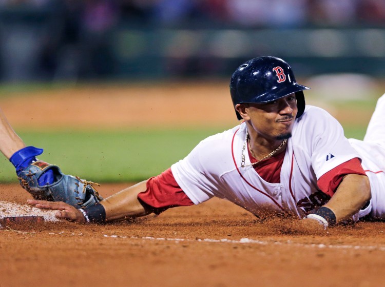 Boston’s Mookie Betts dives back safely under the tag of Kansas City first baseman Eric Hosmer on a pick-off attempt in the seventh inning Thursday at Fenway Park. The Associated Press