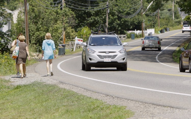 Women walk along Ridge Road in York near the site where police say that Carolyn Lee, 21, of York struck Emily Zarnoch, 23, of Massachusetts early Tuesday morning. Zarnoch died a few hours later of her injuries and police say that Lee was driving drunk at the time of the accident. Gregory Rec / Staff Photographer
