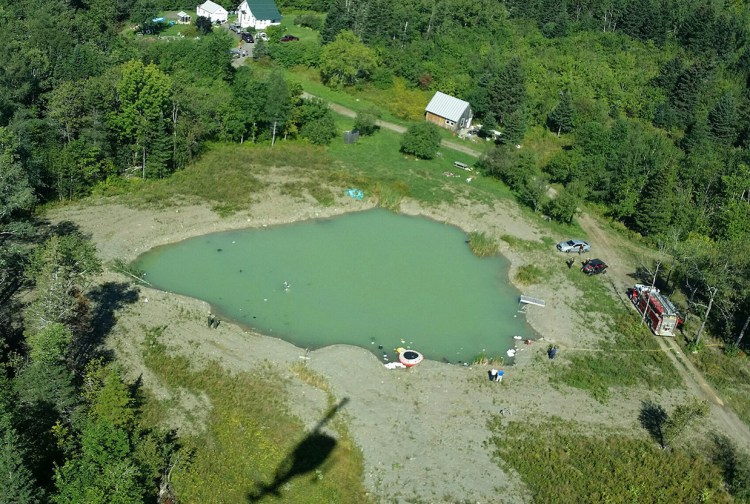 Aerial view of pond where plane wreckage was discovered Thursday morning. Crews are draining the pond so emergency responders can recover the pilot's body and the plane. Maine Forest Service photo