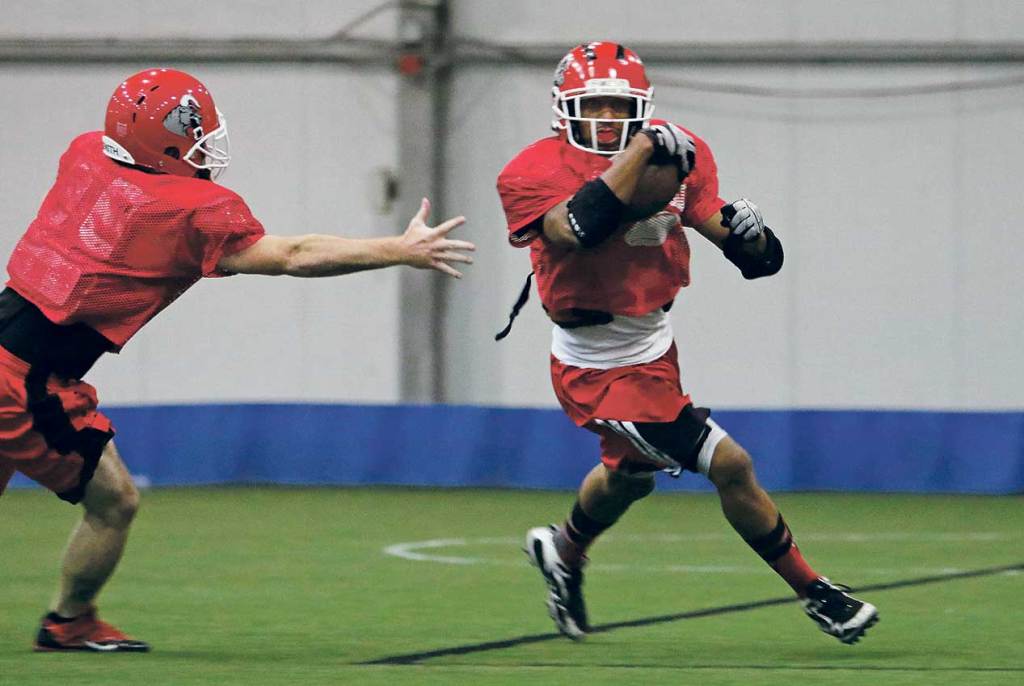 Brandon Bennett, right, looks for some room to run on a kick-return drill as Kevin Corbin pursues during a practice for the Southern Maine Raging Bulls. Jill Brady/Staff Photographer