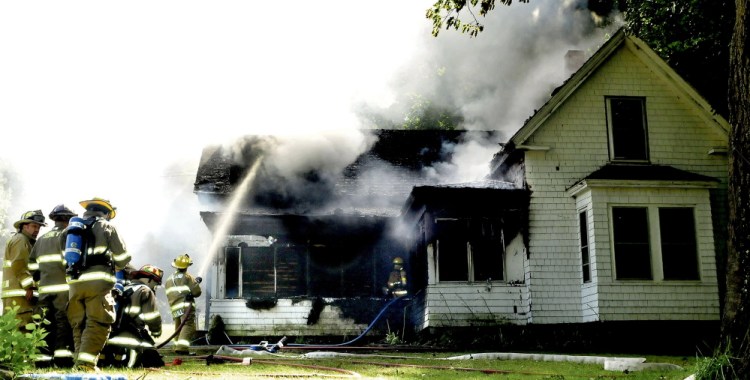 Firefighters from several departments battle a fire that destroyed a home on Swan Hill Road in Oakland on Monday.
