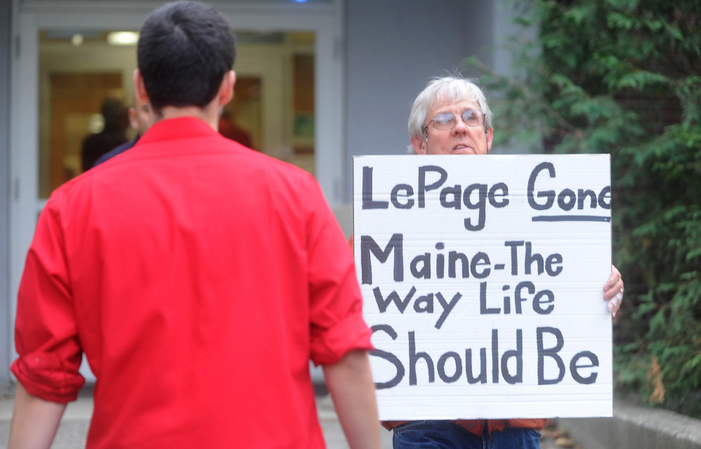 A protester leaves Preble Hall on Tuesday after showing his sign in opposition to Gov. Paul LePage at the University of Maine at Farmington.
Michael G. Seamans/Morning Sentinel