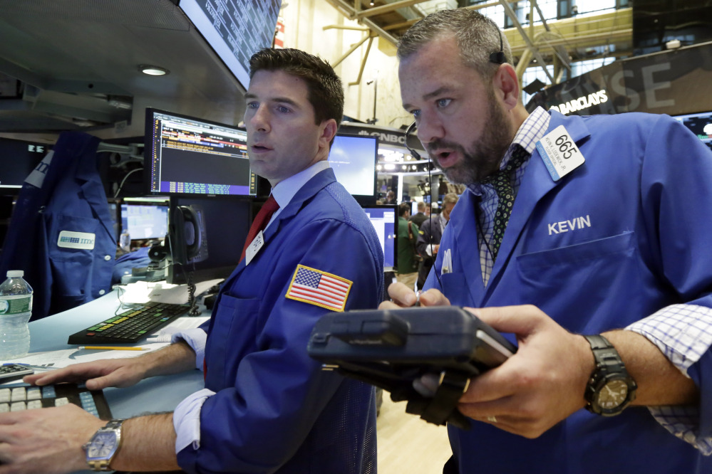 Specialist Thomas McArdle, left, and trader Kevin Lodewick work on the floor of the New York Stock Exchange on Wednesday. On Thursday, stocks continued to gain.