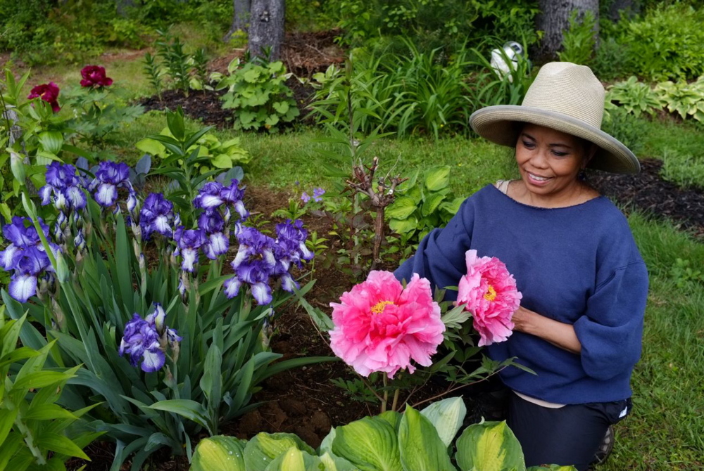 Marietta Atienza works in her Gorham garden by day and as a nurse at Maine Medical Center by night. Her property has the feel of an English cottage garden, with paths and statuary.