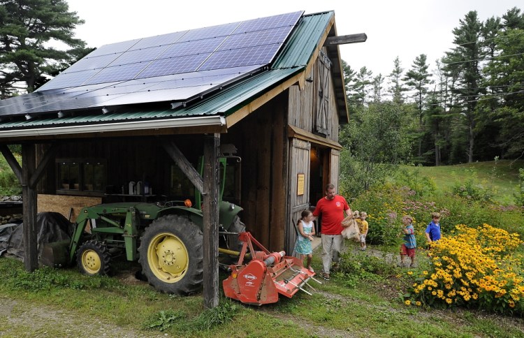 New solar panels cover the roof of a barn at Little Ridge Farm in Lisbon Falls, where Nick Craney of Bath and his children pick up vegetables. The energy project was a  large investment for the small farm, about $18,000, but a federal tax credit for solar projects and a U.S. Department of Agriculture energy grant cut the net cost to $8,000.