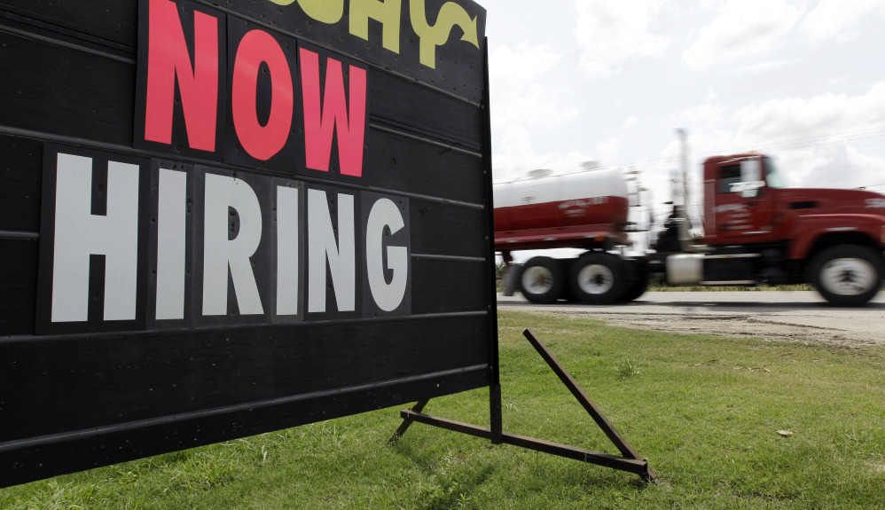 An oil truck passes a “now hiring” sign in Kennedy, Texas. With the Federal Reserve edging into the spotlight, the Friday jobs report could trigger changes in Americans’ financial lives.