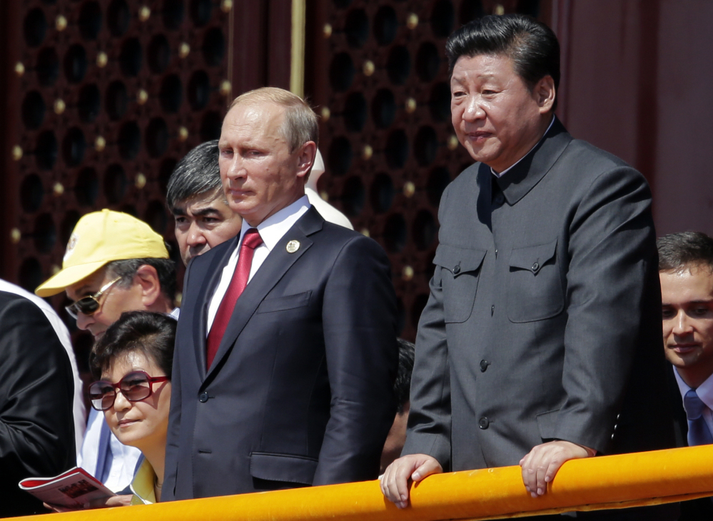 Russian President Vladimir Putin, center, and Chinese President Xi Jinping observe the massive parade.