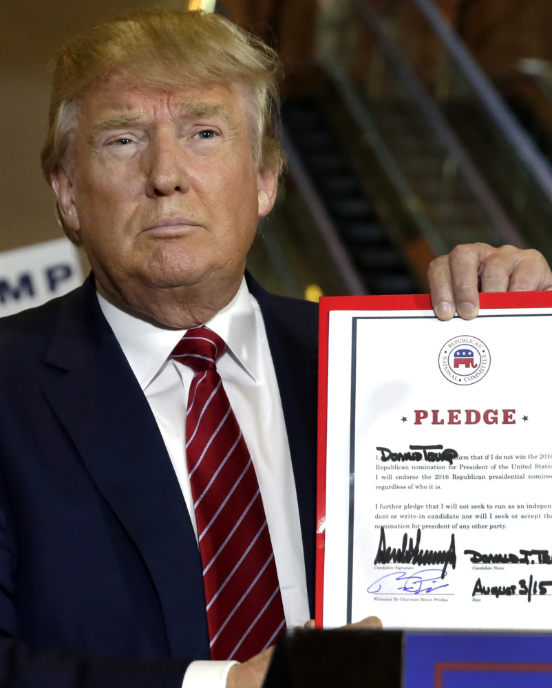 Republican presidential candidate Donald Trump holds his pledge during a news conference at Trump Tower on Thursday.