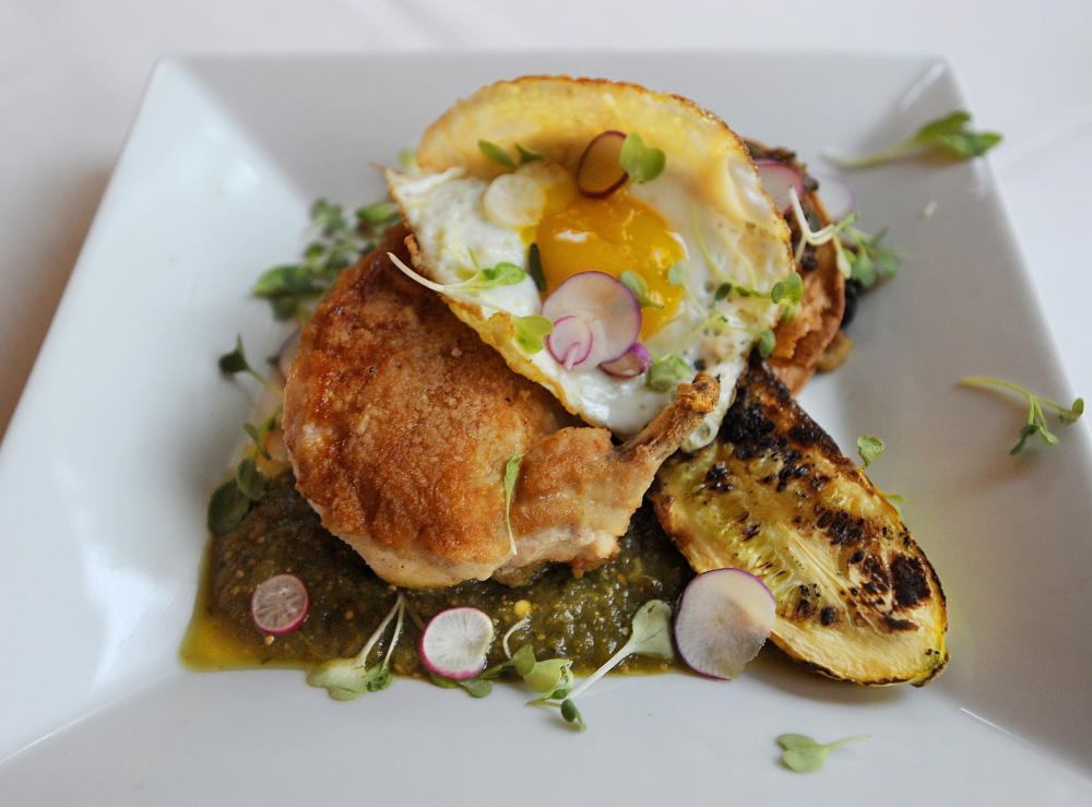 Tortilla-crusted chicken breast with warm tomatillo and green chile salsa, grilled summer squash, house chorizo, black beans and sunny egg strata.