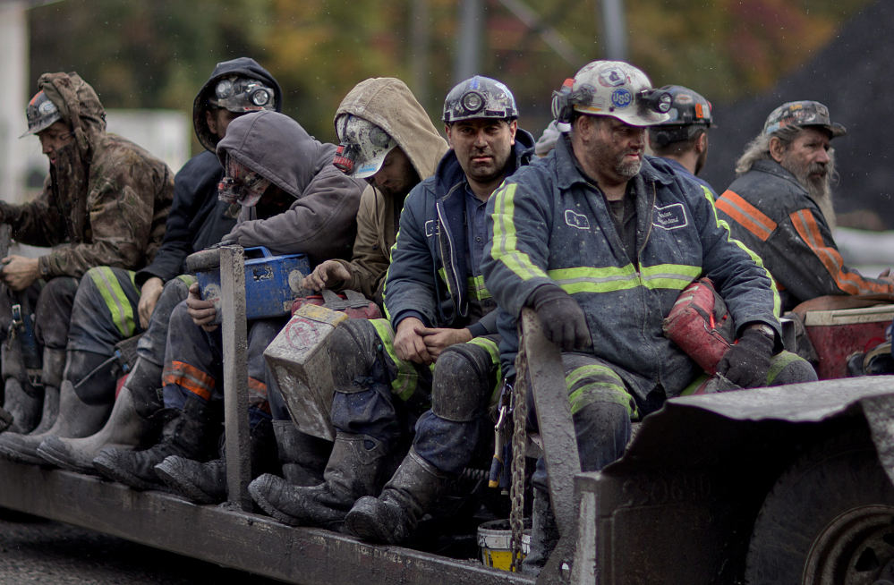 In this Oct. 15, 2014 photo, coal miners return on a buggy after working a shift underground at the Perkins Branch Coal Mine in Cumberland, Ky. The Associated Press
