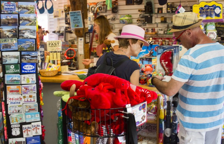 Visitors browse in the Ogunquit Camera Shop, which also sells toys and kites. Tracy Smith, who has worked there for 21 years, said business has been excellent this summer, partly because “people are feeling better about the economy, better about their spending.”