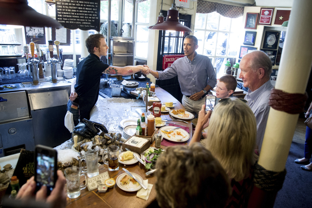 President Obama greets people at Ye Olde Union Oyster House on Monday in Boston. 
The Associated Press