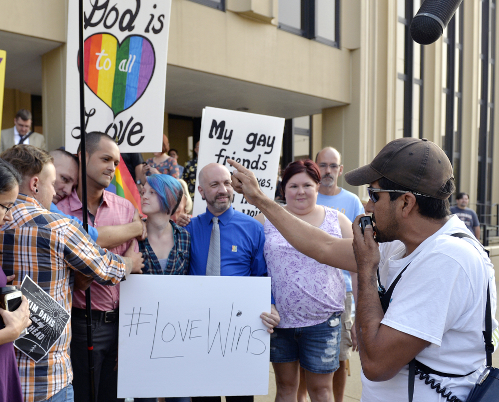 Edgar Orea, right, preaches to a group of same-sex marriage supporters gathered outside the Carl D. Perkins Federal Building in Ashland, Ky., last Thursday. Later that day, Rowan County Clerk Kim Davis was found in contempt of court for refusing to issue marriage licenses.