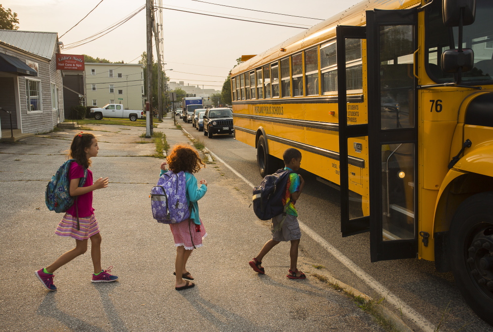 Children board their bus at Edwards and Congress streets. A Portland school official says the district is monitoring the new bus stops and it’s open to changes if necessary.
