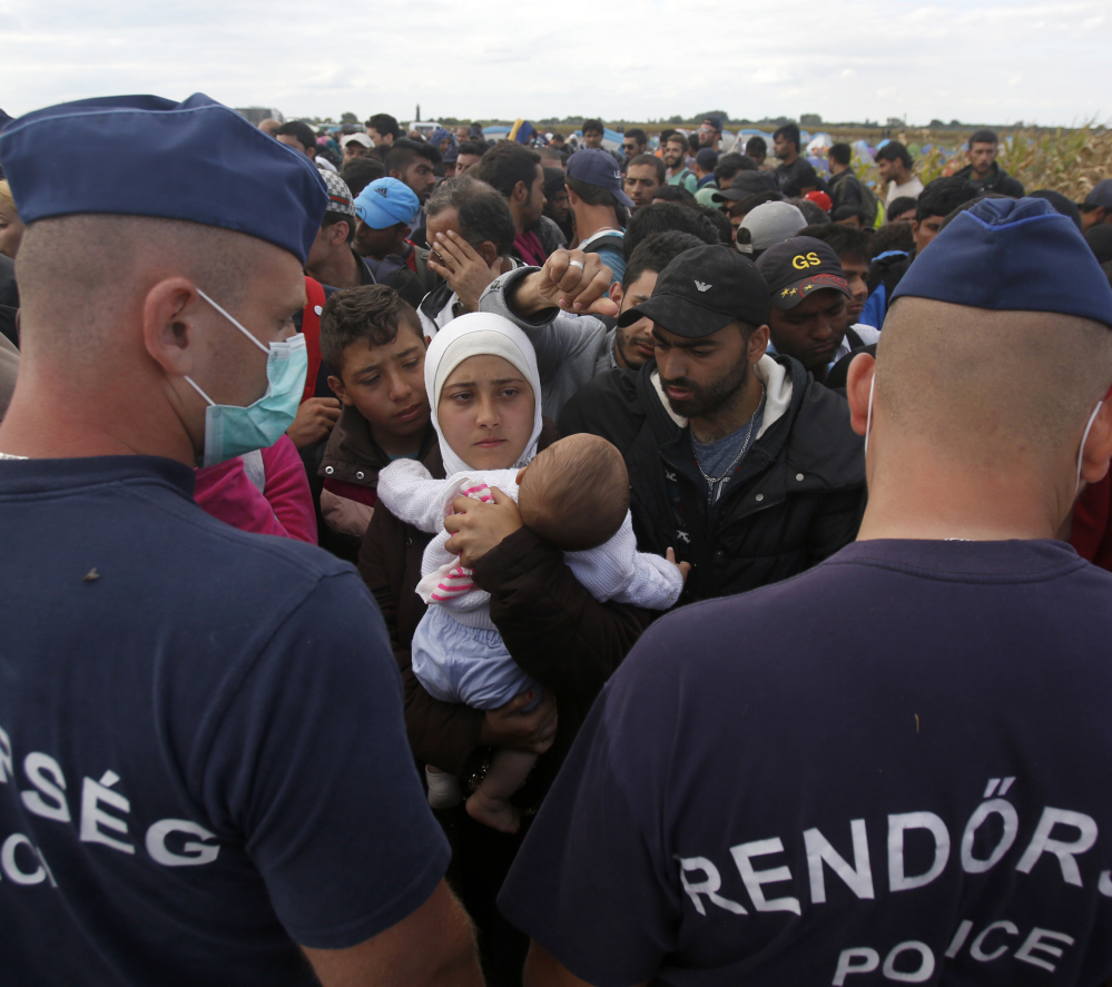 Hungarian police officers face a crowd of asylum-seekers in Roszke, Hungary, on Tuesday. The U.N. High Commissioner for Refugees called the European asylum system “chaotic.”