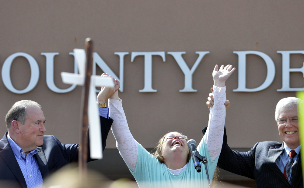 Rowan County Clerk Kim Davis, center, with Republican presidential candidate Mike Huckabee, left, and attorney Mat Staver, founder of the Liberty Counsel, the Christian law firm representing Davis, at her side, cries out after being released from the Carter County Detention Center, Tuesday in Grayson, Ky.