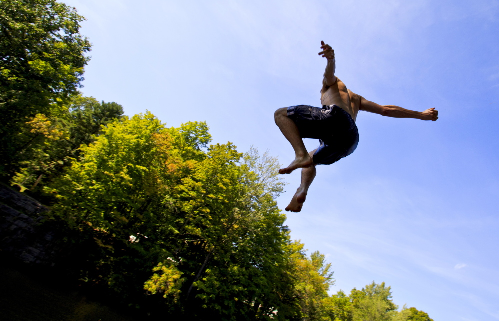 Seventeen-year-old John Vedral of Buxton leaps Wednesday into the Saco River in Buxton after he and fellow Bonny Eagle High School students were dismissed early because of the heat. “It’s an extremely rare situation, but ... it seemed like the safest thing to do for our kids,” said SAD 6 Superintendent Frank Sherburne, who expressed concern that students might become dehydrated.