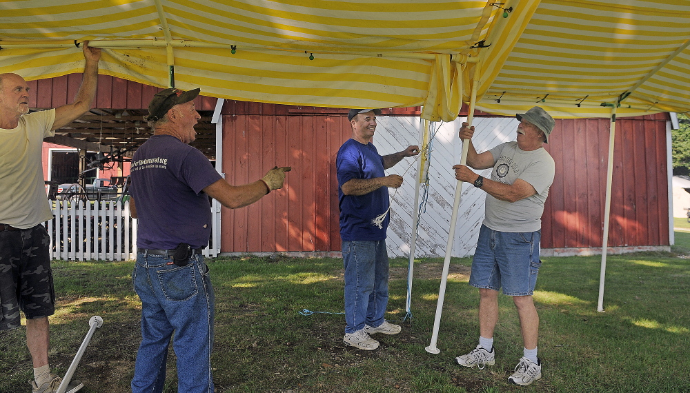 Volunteers getting ready for the Litchfield Fair erect a canopy Wednesday.